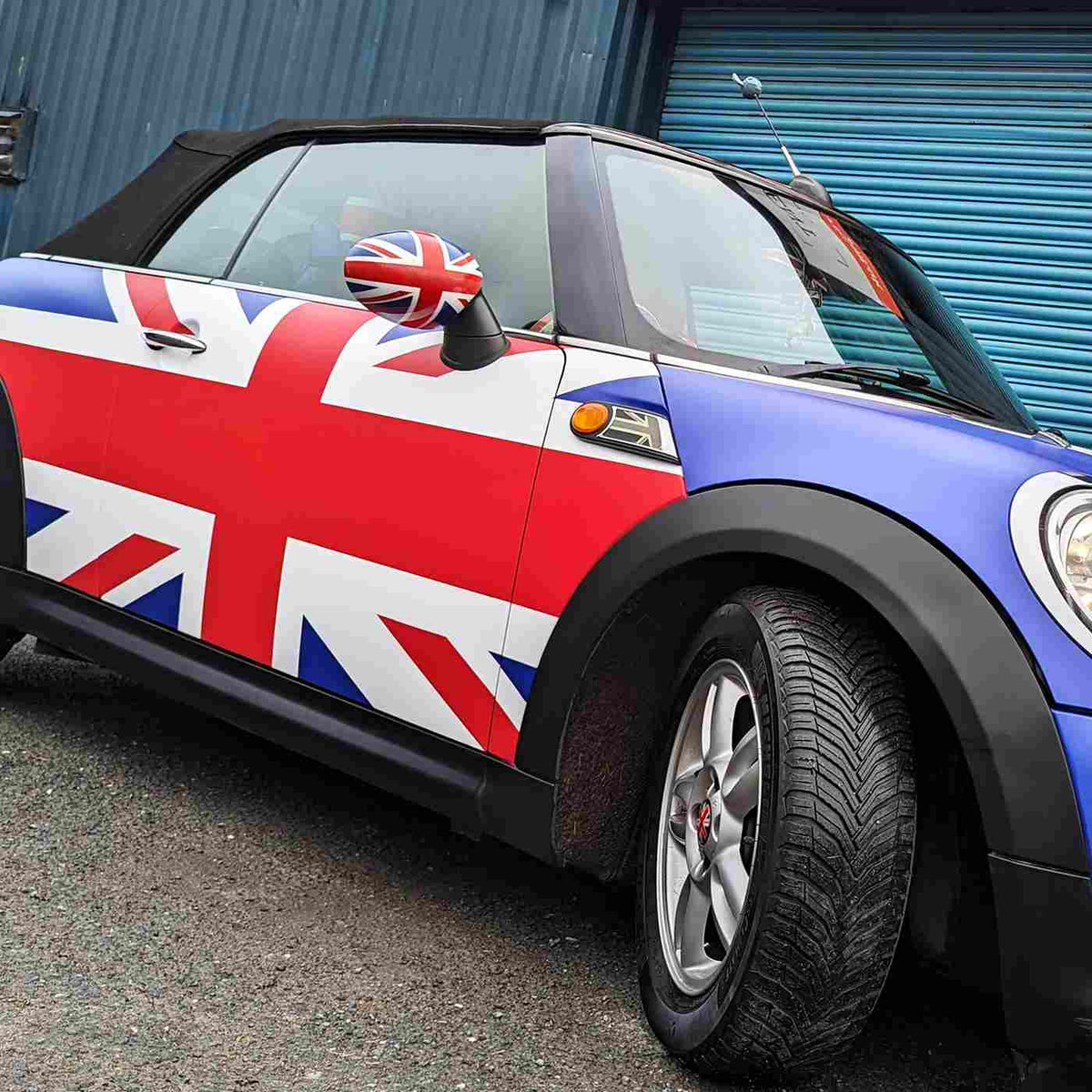 Flag graphics on a compact convertible, from the MetaGuard MG-X manufacturer gallery.