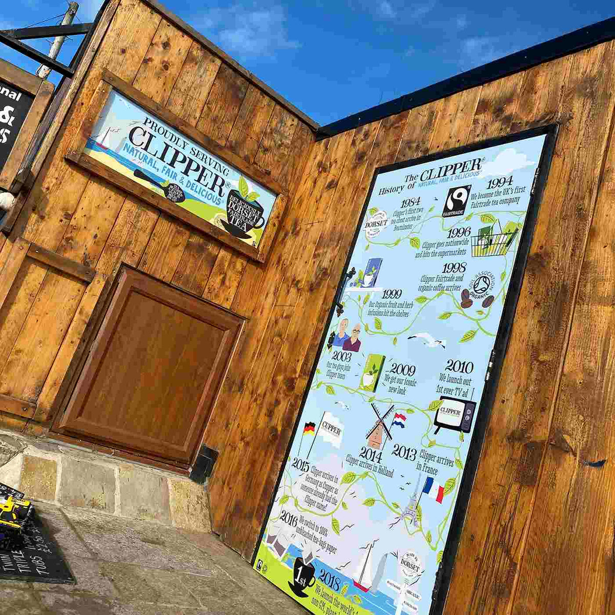 Clipper retail signs on flat panels outside a timber-clad building, from the Metamark MD5 gallery.