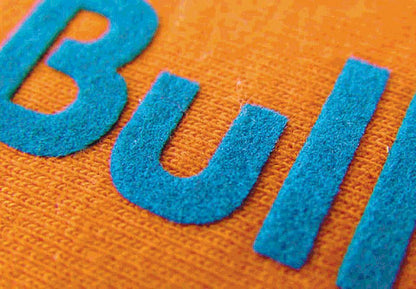 Representative blue flocked lettering on orange fabric, showing raised texture; finished application shown, not the supplied sheet or every color.